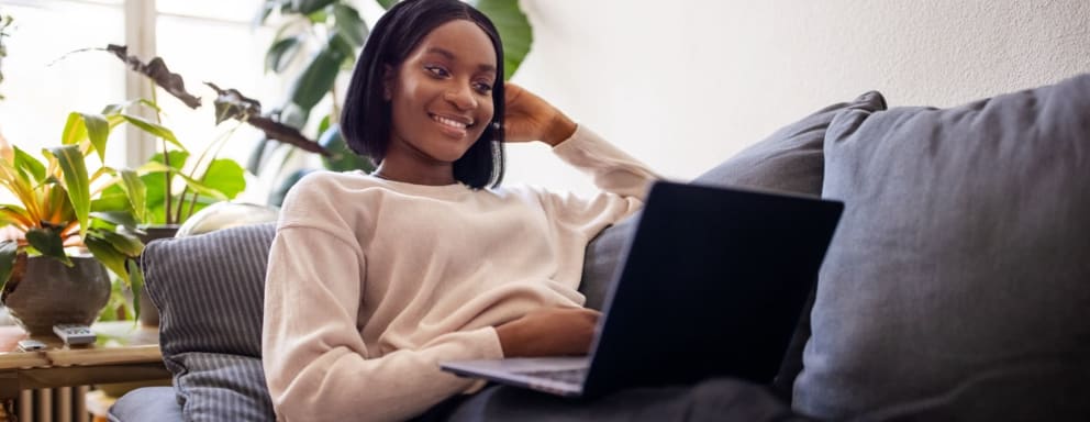 Woman at home on couch on laptop