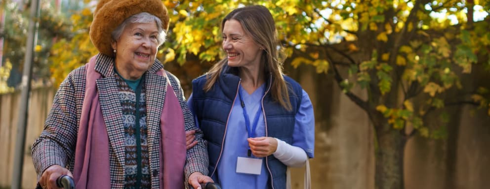 Nurse helping elderly patient outside