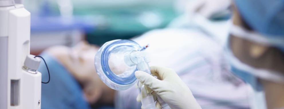 Nurse anesthetist holding mask