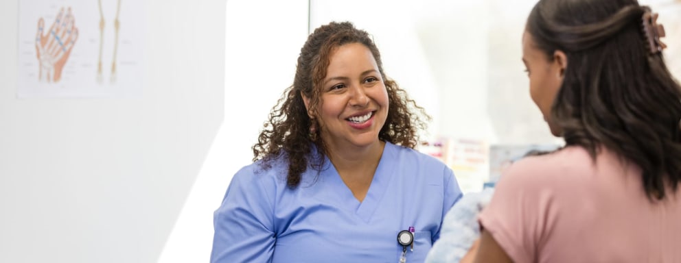 Nurse speaking to mother and baby in exam room