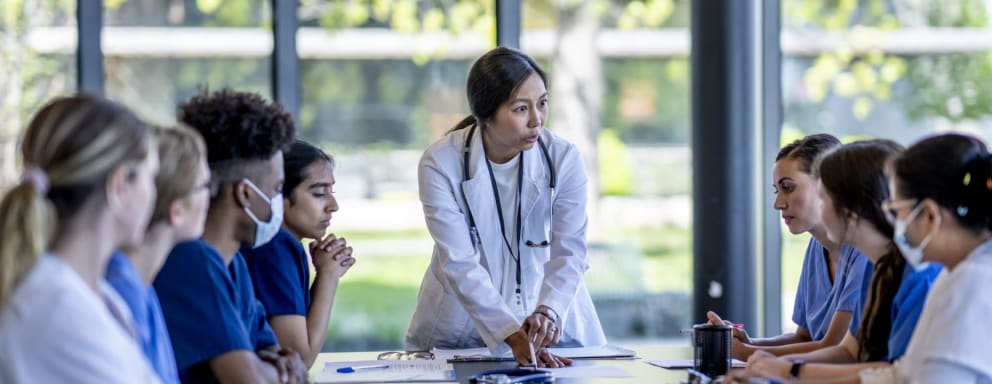 Nurses in a serious meeting around a conference table