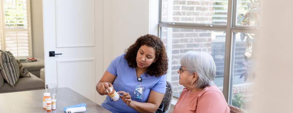Nurse helping a senior patient with her medications at home