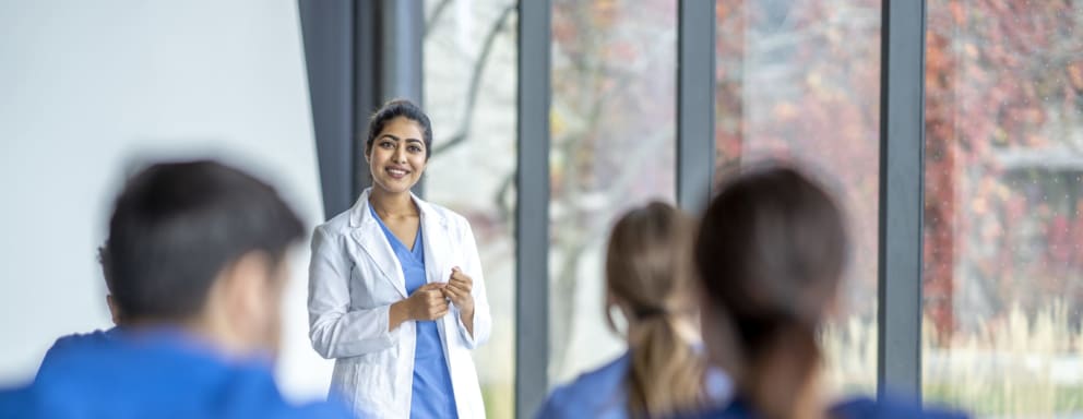 Nursing lecturer talking to students in classroom