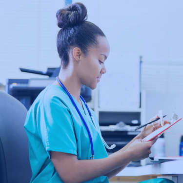 nurse writing on clipboard in office