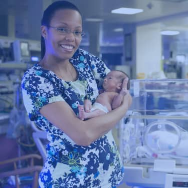 nurse holding newborn baby