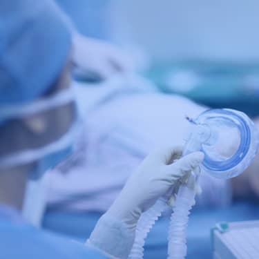 nurse holding anesthesia mask in surgery room