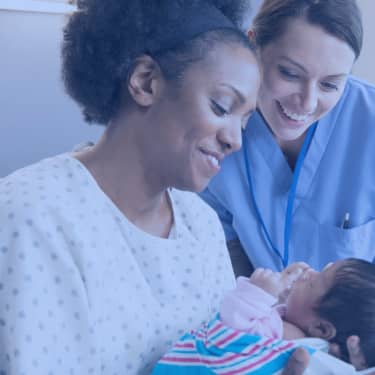 new mom holding newborn beside nurse