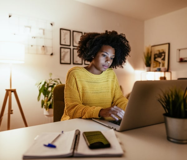 Woman typing on laptop in home office