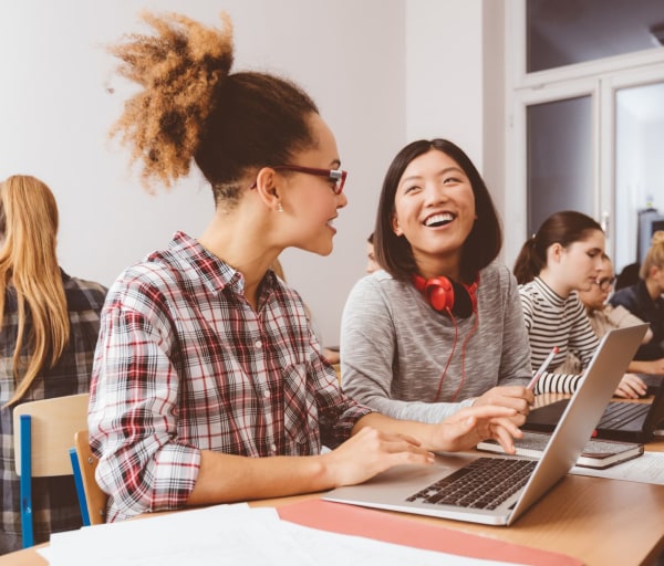 Group of women students in classroom on laptops
