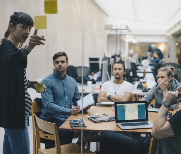 Woman giving presentation to casual group meeting