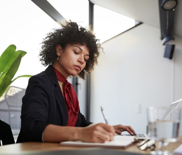 Person in office writing in notebook