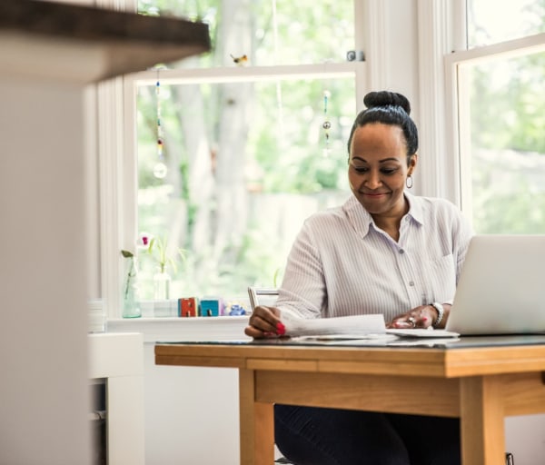 Woman working on laptop in kitchen