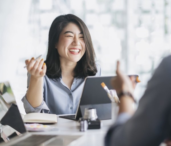 Woman in meeting smiling at desk