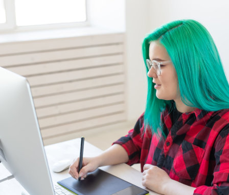 Woman drawing on a digital tablet using a desktop computer
