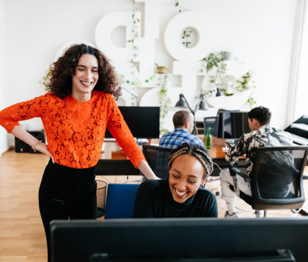Two people looking at a computer in an office