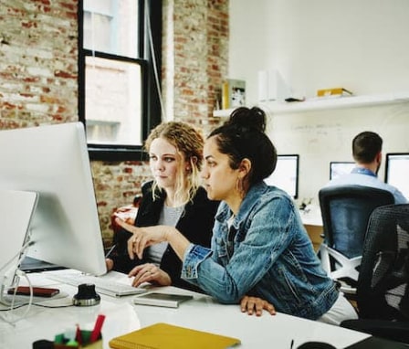 Two women working together on a computer