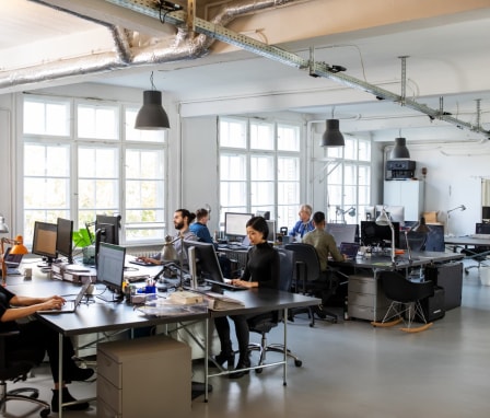 People coding on separate computers in a room