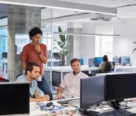 Three colleagues working together on a computer