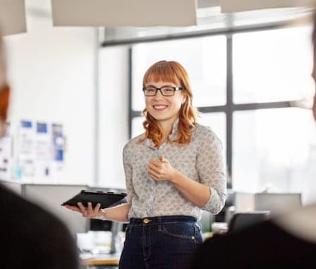 Woman holding tablet and talking with colleagues