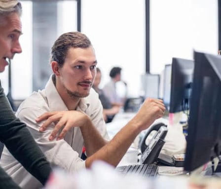 Person helping someone else on computer