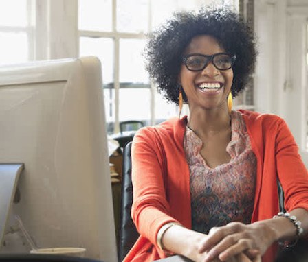 Woman smiling while sitting at computer desk