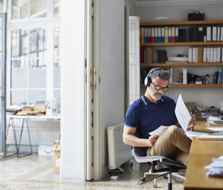 Man wearing headphones doing work at desk