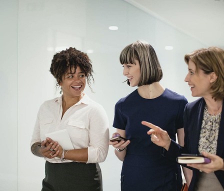 Three women talking in hallway