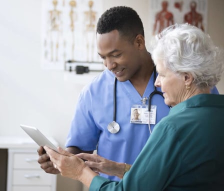 Nurse and patient using digital tablet in clinic