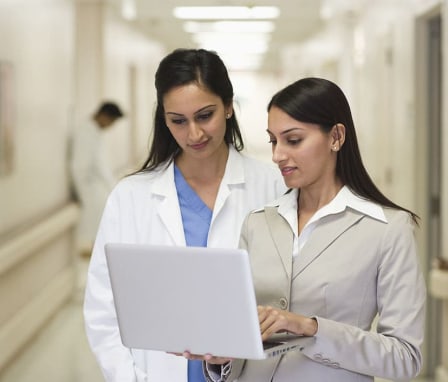 Two medical workers looking at a laptop