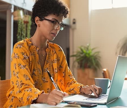 Women taking notes at laptop