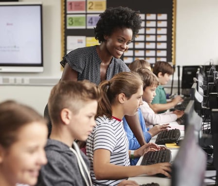 Computer teacher instructing students