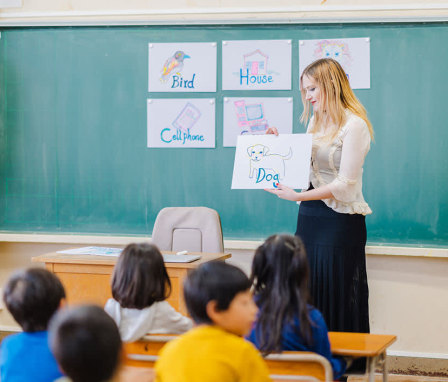 Elementary teacher holding a picture of a dog