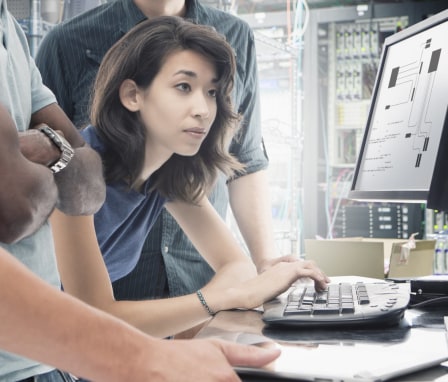 Person typing on keyboard, looking at computer