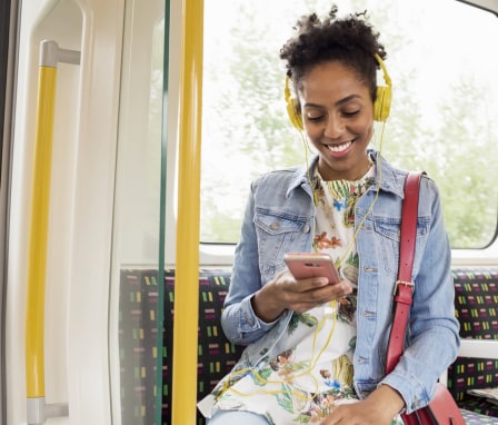 Woman listening to her phone through headphones on a bus