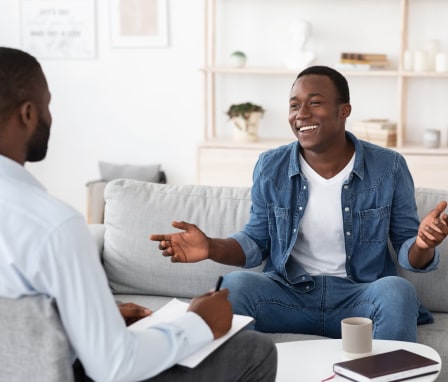 Man smiling and talking to therapist