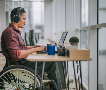 Man in wheelchair on video call on laptop