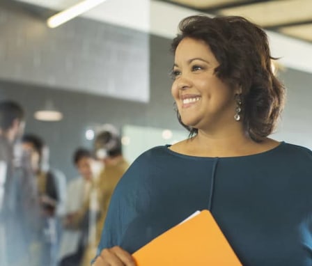 Woman smiling and holding a folder