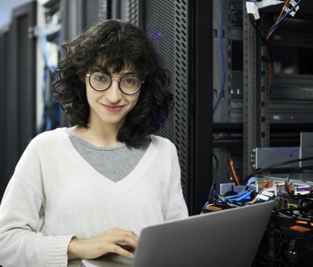 Person in server room holding laptop