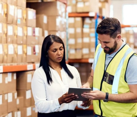 Man and woman working together on tablet in warehouse
