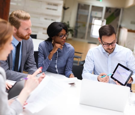 Four business colleagues looking at a graph shown on a tablet