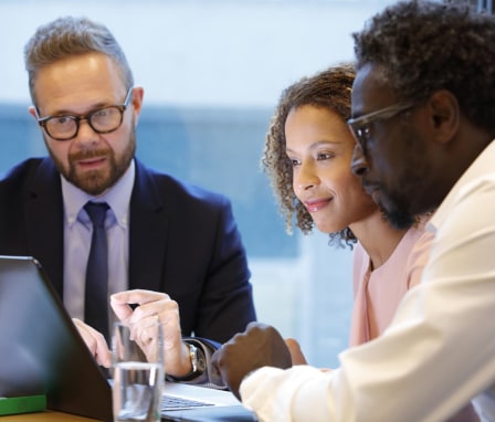 Three people working on a laptop