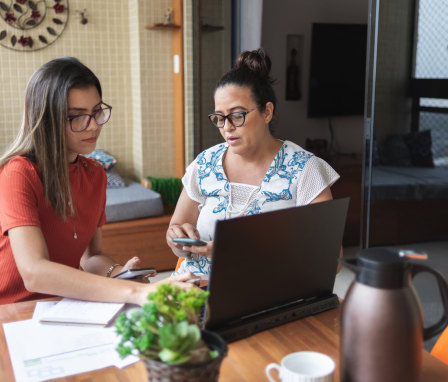 Mother and daughter doing finances together at home
