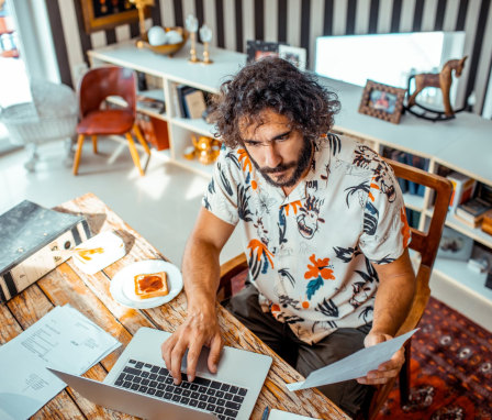 Close up of a young man working on his laptop from home