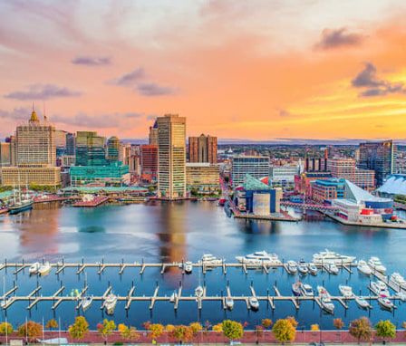 Baltimore, Maryland harbor with skyline in background at sunset