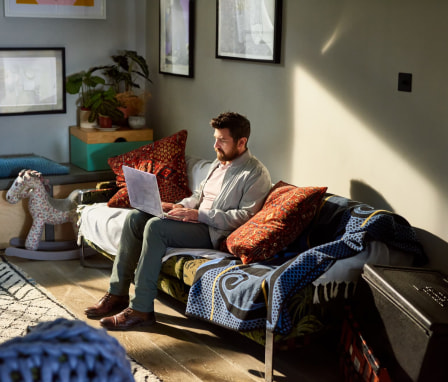 Man working on laptop on couch
