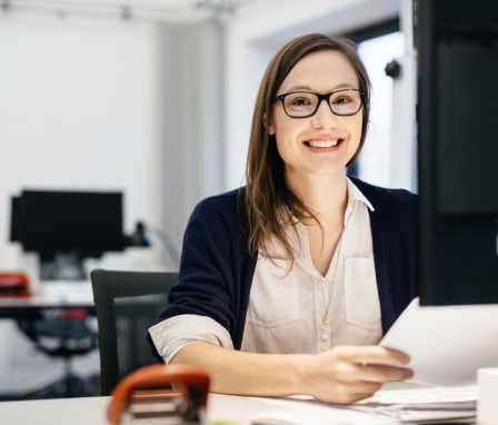 Woman smiling working at computer in office