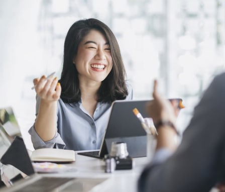 Woman in meeting smiling at desk