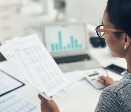 Woman looking at spreadsheets and graphs