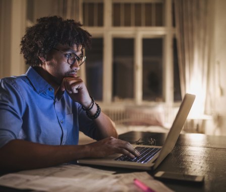 Person looking at laptop on a desk at home