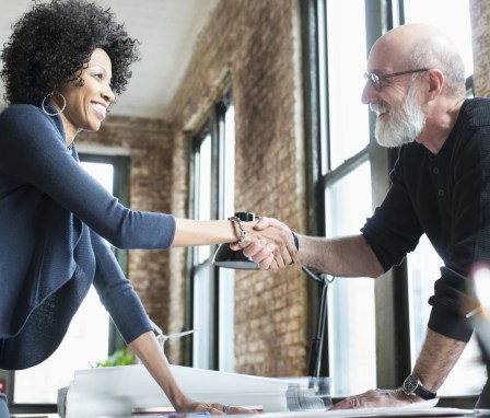 Man and woman smiling and shaking hands